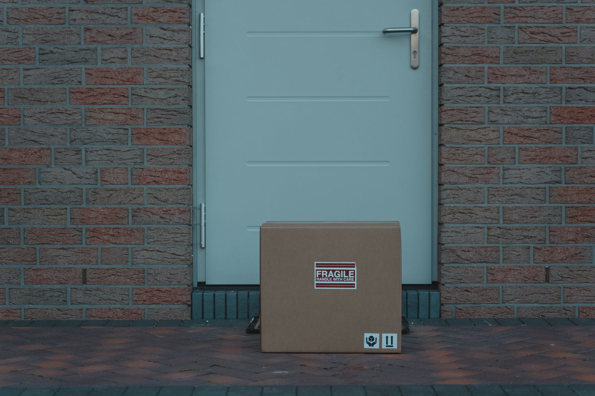 A cardboard parcel left beside a white door